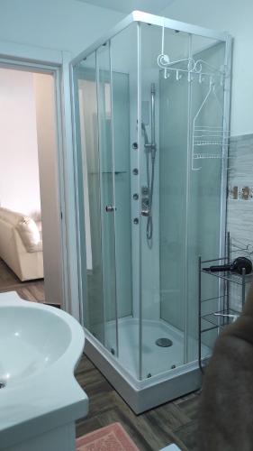 a glass shower in a bathroom with a tub at Villa Erilia in San Giovanni Suèrgiu