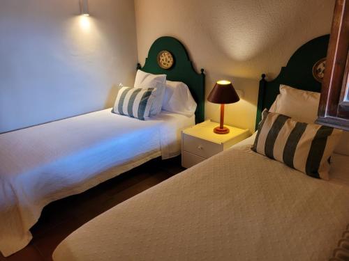 - une chambre avec 2 lits et une lampe sur une table de chevet dans l'établissement Casa de campo en el Empordà, à Cruïlles