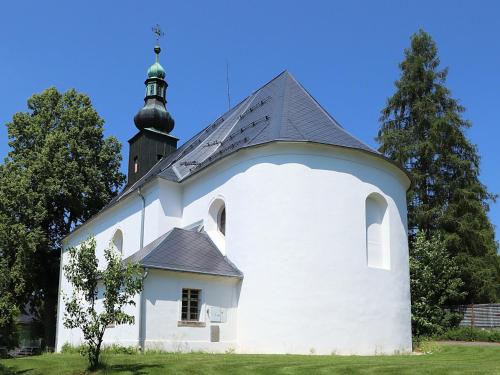 a small white church with a black roof at Apartmán Levandule in Mařenice