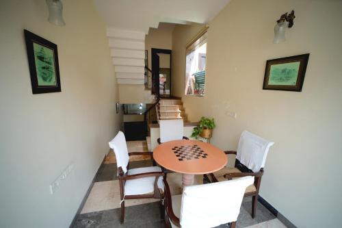 a dining room with a table and white chairs at Bansi Home Stay in Agra
