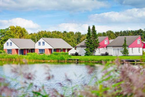 a row of houses next to a body of water at Veluwe Strandbad Elburg in Elburg