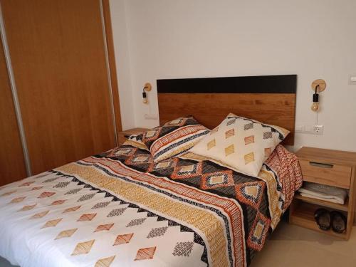 ein Bett mit einer Bettdecke und Kissen darauf in der Unterkunft Apartamento en pleno centro in Alhama de Murcia
