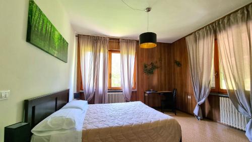 B&B Naturista e Spa Mondoselvaggio في لوكّا: غرفة نوم بسرير كبير ونافذة