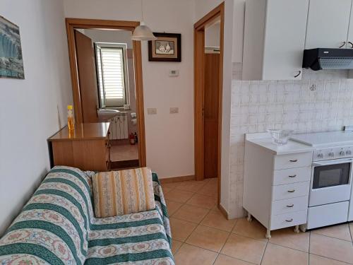 ein Wohnzimmer mit einem Sofa und einer Küche in der Unterkunft La casa vacanza in Falcone