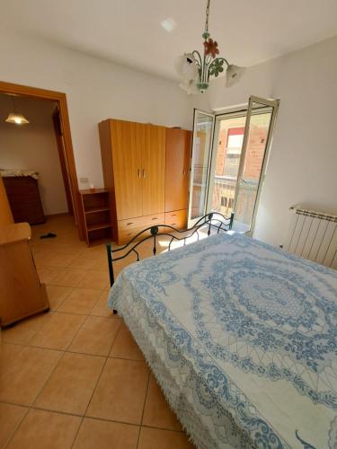 ein Schlafzimmer mit einem Bett und einem großen Fenster in der Unterkunft La casa vacanza in Falcone