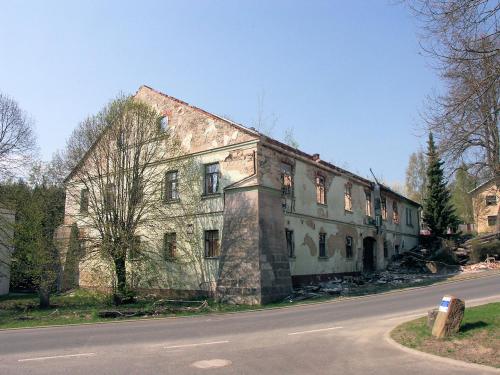 an old building sitting on the side of a road at Apartmán Levandule in Mařenice