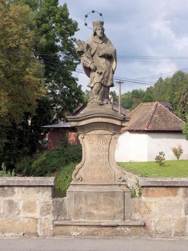 a statue of a man on top of a wall at Apartmán Levandule in Mařenice