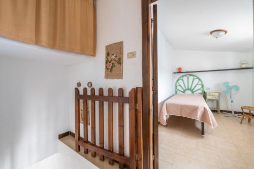 um quarto com um berço e uma cama num quarto em Spiaggia Grande Junior em Calasetta