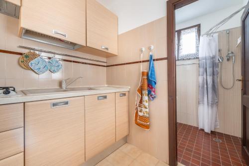 uma pequena cozinha com um lavatório e um chuveiro em Spiaggia Grande Junior em Calasetta