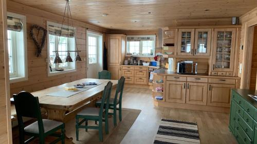 a kitchen with a large wooden table and chairs at Panorama Logde Stryn, with Jacuzzi, Sauna and Spectacular Views! in Stryn