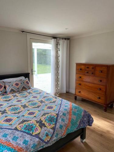 una camera con letto, cassettiera e finestra di Bellbourie Cottage a Firefly