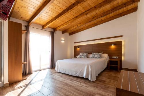 ein Schlafzimmer mit einem weißen Bett und einem großen Fenster in der Unterkunft Hotel Avenida in Benicàssim