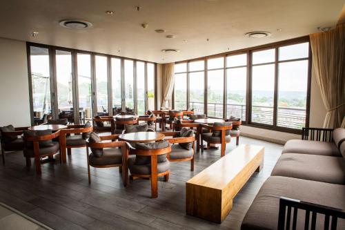 a restaurant with tables and chairs and large windows at Southern Sun Hyde Park Sandton in Johannesburg