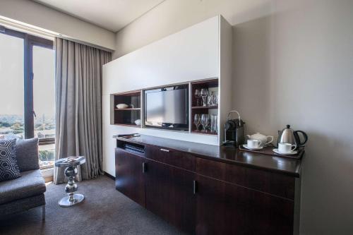 a living room with a television and a couch at Southern Sun Hyde Park Sandton in Johannesburg