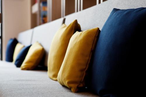 a row of yellow pillows sitting on a bed at Holiday Inn Express Bochum by IHG in Bochum