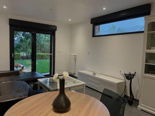 un vase avec des fleurs sur une table dans un salon dans l'établissement Paisible Duplexe sur Villeneuve d ascq, à Annappes