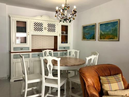 een keuken met een tafel en stoelen en een kroonluchter bij Apartamento céntrico en la playa de Bueu in Bueu