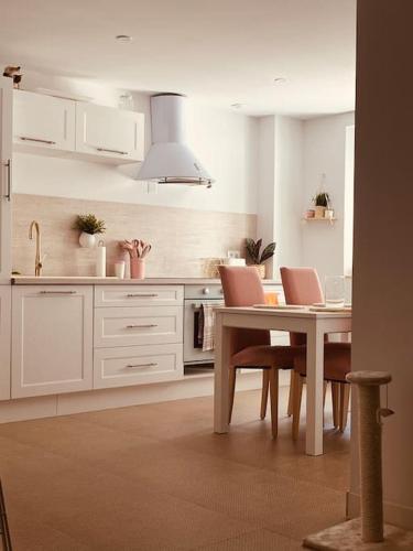 une cuisine avec des armoires blanches et une table et des chaises dans l'établissement Appartement fontaine de Vaucluse, à Fontaine-de-Vaucluse