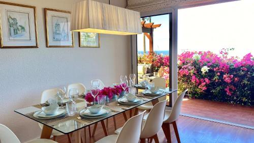 een eetkamer met een tafel en stoelen en bloemen bij Casa ideal para famílias com vista mar desafogada in Funchal