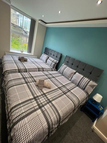 dos camas sentadas una al lado de la otra en un dormitorio en Edgerton Suites, en Huddersfield