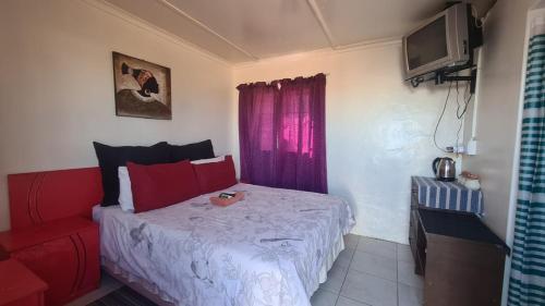 a bedroom with a bed and a red couch at Hollywood Lodge in Steinkopf