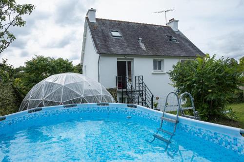 une maison avec une piscine devant une maison dans l'établissement Villa Brelevenez 7 chambres Spa Piscine Jardin, à Lannion
