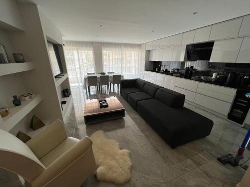 un salon avec un canapé noir et une cuisine dans l'établissement Cannes Centre ville, à Cannes