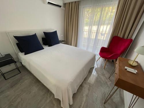 une chambre avec un grand lit blanc et une chaise rouge dans l'établissement Cannes Centre ville, à Cannes