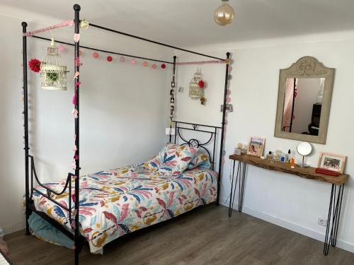 a bedroom with a canopy bed and a mirror at Chambre d’hôte à 200 m de la plage in Lavra