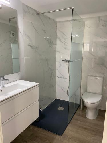 a bathroom with a toilet and a glass shower at Chambre d’hôte à 200 m de la plage in Lavra