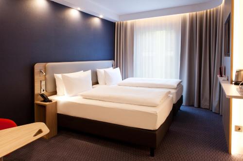 a hotel room with a bed and a window at Holiday Inn Express Bochum by IHG in Bochum