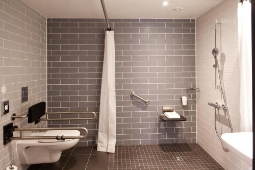 a bathroom with a shower and a toilet and a sink at Holiday Inn Express Bochum by IHG in Bochum