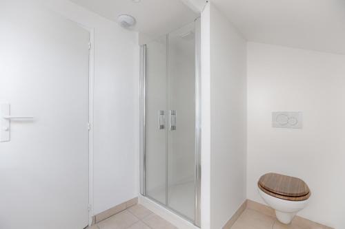 a bathroom with a toilet and a glass shower at Le Magnolia - A 10 minutes de Disneyland in Lagny