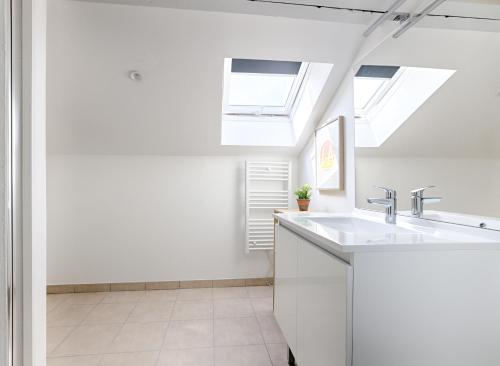 a white kitchen with skylights and a sink at Le Magnolia - A 10 minutes de Disneyland in Lagny