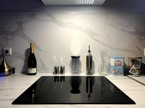 un comptoir avec des bouteilles de vin et un comptoir avec un comptoir sidx sidx sidx dans l'établissement Red love-room / Balnéo & plus !, à Souppes-sur-Loing