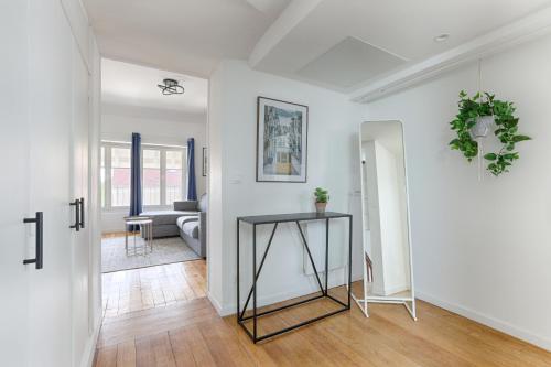 a white living room with a table and a couch at Le Magnolia - A 10 minutes de Disneyland in Lagny