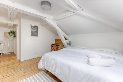 a white bedroom with a white bed and stairs at Le Magnolia - A 10 minutes de Disneyland in Lagny