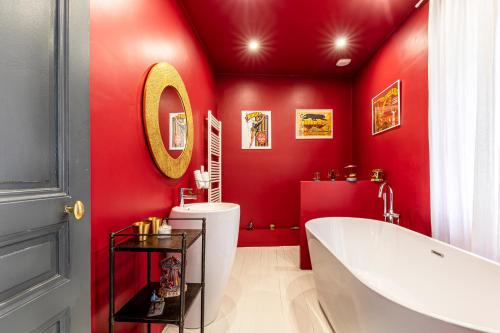 a bathroom with red walls and a tub and a sink at La Villa Lauvray in Vétheuil