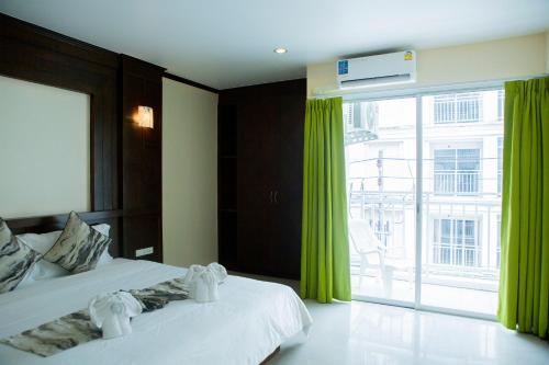 un dormitorio con dos camas y una ventana grande en Blue Skyline Hotel, en Patong Beach