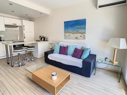 un salon avec un canapé et une cuisine dans l'établissement Appartements Medicis, à Cannes