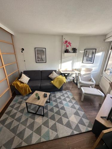 uma sala de estar com um sofá e uma mesa em Studio Élégant à Cergy em Cergy