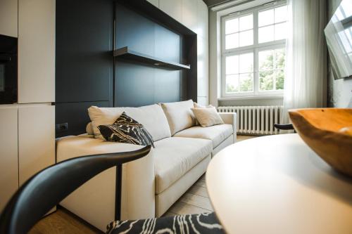 a living room with a white couch and a window at Luxury studio with a park view in Rīga