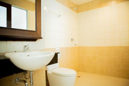 y baño con aseo blanco y lavamanos. en Odin Andaman Hotel en Patong