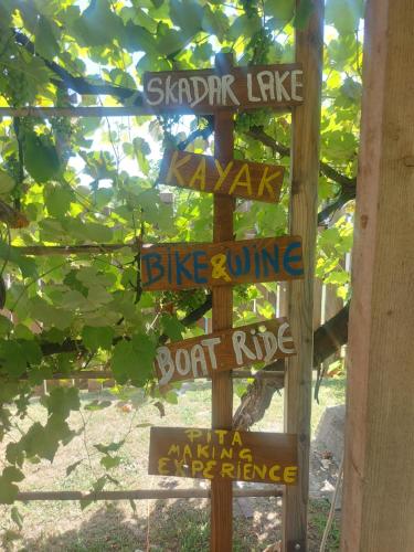 a wooden sign with street signs on it at Balabani Local Stay in Podgorica