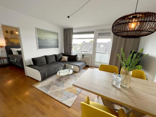 een woonkamer met een tafel en een bank bij Beautiful 2-room apartment with balkony in Willich in Willich