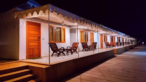 a row of chairs on a balcony at night at The Sky Imperial Nakoda Green Valley Resort in Nāthdwāra