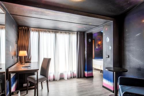 a room with a desk and a bedroom with a bed at Muraless Art Hotel - WorldHotels Crafted in Castel d'Azzano
