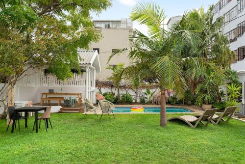 a backyard with a table and chairs and a palm tree at Neighbourgood Hill in Green Point