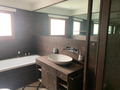 a bathroom with a sink and a tub and a mirror at chesa collina in Pontresina