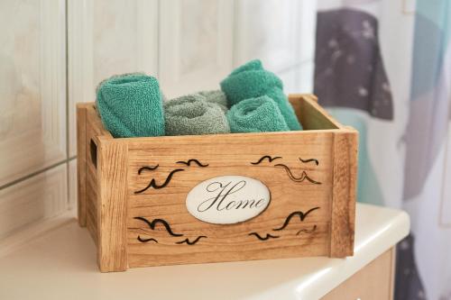 una caja de madera llena de toallas verdes en una mesa en Exclusive Villa - Amazing View & Private Pool en Agia Triada